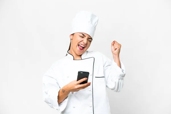 Mujer Joven Chef Sobre Fondo Blanco Aislado Con Teléfono Posición —  Fotos de Stock