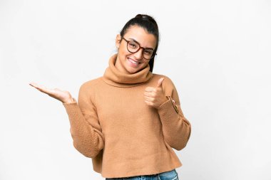 İzole edilmiş beyaz arka plan üzerinde genç bir kadın. Avucunun içinde hayali bir şey tutuyor. Bir ilan vermek için.