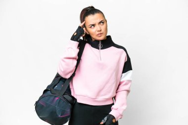 Young sport woman with sport bag over isolated white background having doubts and with confuse face expression