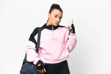 Young sport woman with sport bag over isolated white background pointing with the index finger a great idea