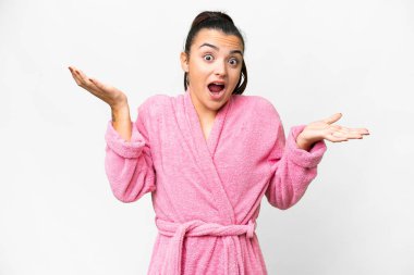 Yüzünde şok ifadesi olan, izole edilmiş beyaz bir arka planı olan bornozlu genç bir kadın.