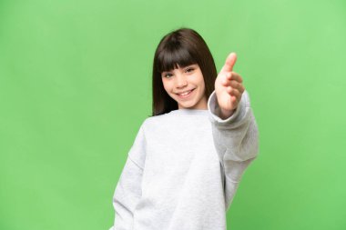 İzole edilmiş yeşil krom anahtar geçmişi olan küçük kız iyi bir anlaşma için el sıkışıyor.