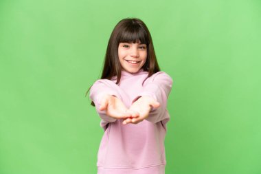 İzole edilmiş yeşil krom anahtar arka plan üzerinde küçük bir kız bir reklam eklemek için fotokopi uzayı hayali tutar