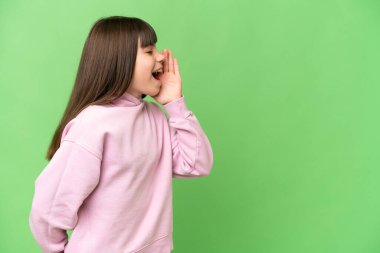 Yeşil renkli arka planda küçük bir kız ağzı açık bağırıyor.