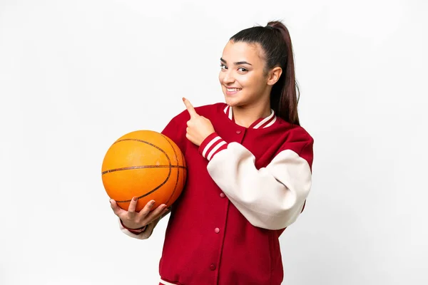 若いです女性プレイバスケットボール上の隔離された白い背景を指す — ストック写真