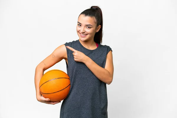 年轻美丽的女子在孤独的白人背景上打篮球 指着侧边 — 图库照片