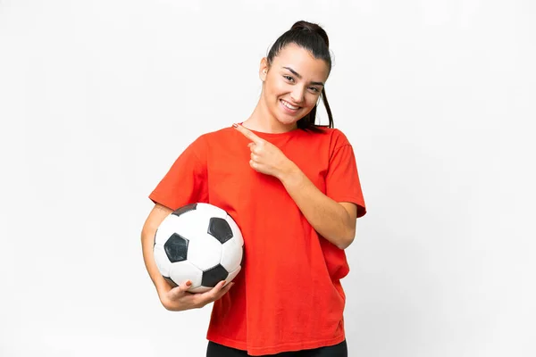 年轻的漂亮女人用足球在孤立的白色背景上指着侧边 — 图库照片