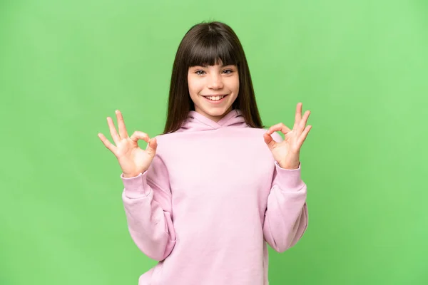 Yeşil Renkli Arka Plan Üzerinde Küçük Bir Kız Tamam Işareti — Stok fotoğraf