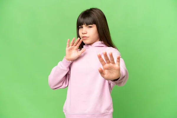 小女孩在孤零零的绿色彩色关键背景上紧张地把手伸向前方 — 图库照片