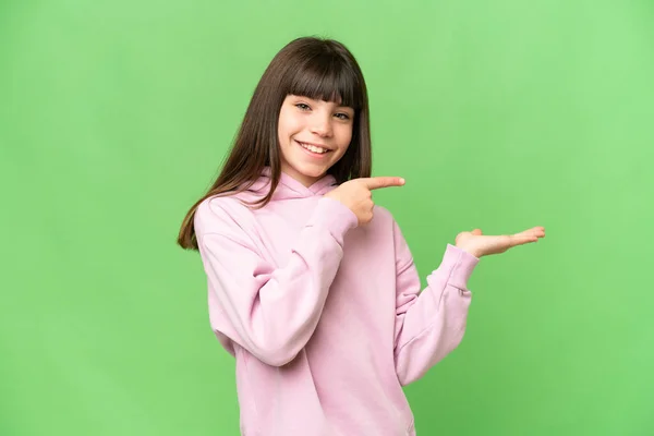 小さな女の子以上隔離された緑のクロマキー背景を保持コピースペース想像上のザ手のひらに挿入する広告 — ストック写真