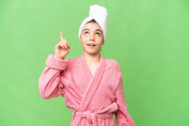 İzole edilmiş krom anahtar geçmişi olan bornozlu küçük bir kız yukarı bakıyor ve şaşırıyor.