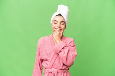 İzole edilmiş krom anahtar arka planda bornozlu küçük bir kız yan tarafa bakıyor.