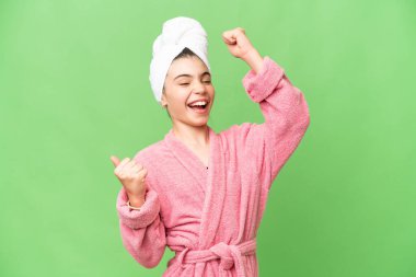 İzole edilmiş renkli bornozlu küçük kız zaferi kutluyor.