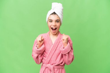 İzole edilmiş krom anahtar geçmişi olan bornozlu küçük bir kız galibiyetini kutluyor.