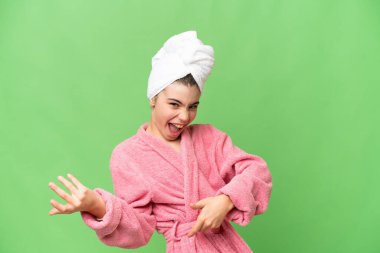 Bornozlu küçük bir kız izole edilmiş krom anahtar arka planda gitar hareketi yapıyor.