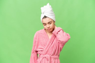 Bornozlu küçük bir kız izole edilmiş bir krom anahtar arka planı ve boyun ağrısı var.