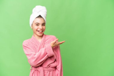 İzole edilmiş krom anahtar geçmişi olan bornozlu küçük bir kız gülümseyerek bir fikir sunuyor.