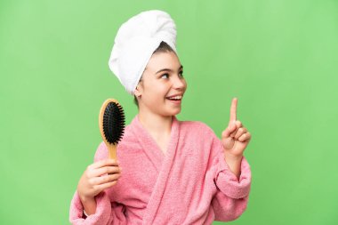 Saçını taramış genç bir kız parmağını kaldırarak çözümü anlamaya çalışıyor.