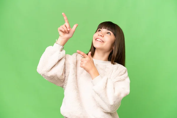 stock image Little girl over isolated green chroma key background pointing with the index finger a great idea