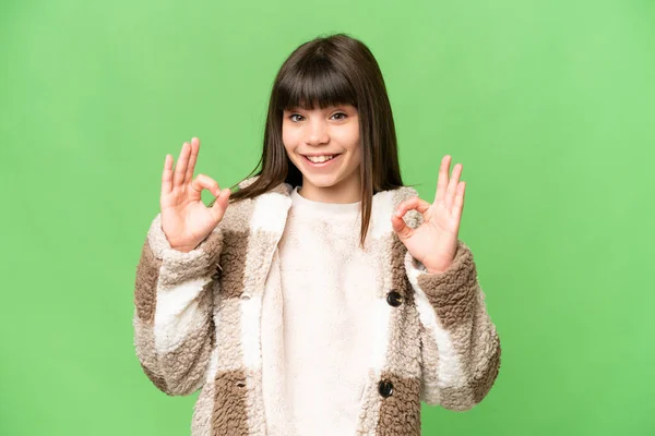 小女孩用双手在孤立的绿色彩色键背景上显示出好的标志 — 图库照片
