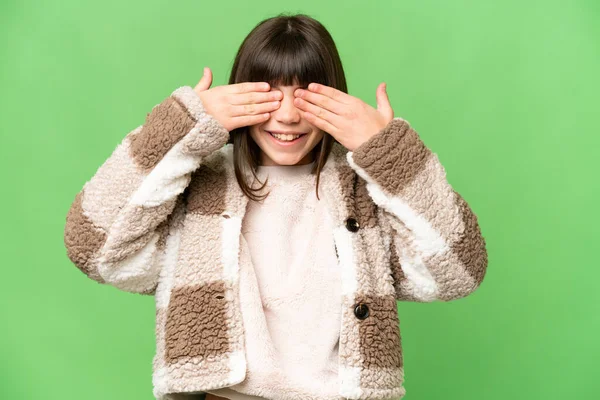 小さな女の子以上隔離された緑のクロマキー背景カバー目によって手と笑顔 — ストック写真