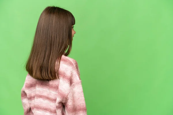 小女孩在孤立的绿色彩色关键背景后面的位置和侧面看 — 图库照片