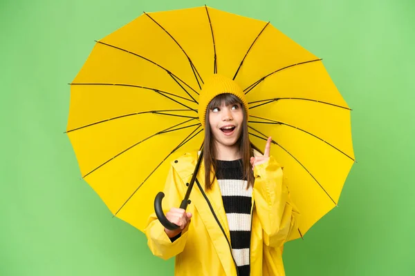 小さな女の子です雨防止コートと傘上の隔離されたクロマキー背景考え方指アップ — ストック写真
