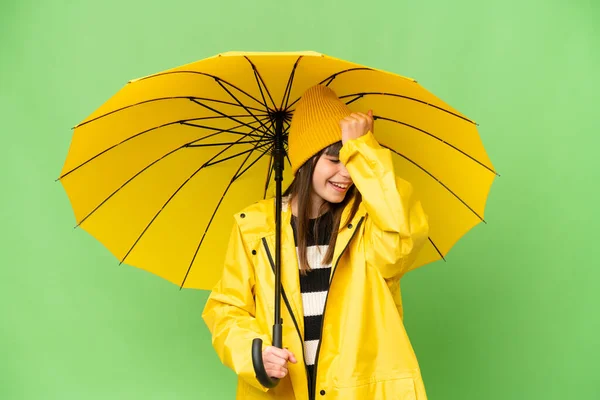 小さな女の子とともにレインプルーフコートと傘上の隔離されたクロマキー背景は何かを実現し 解決策を望んでいます — ストック写真