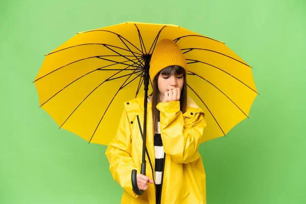小さな女の子とともにレインプルーフコートと傘上の隔離されたクロマキー背景持っています疑問 — ストック写真