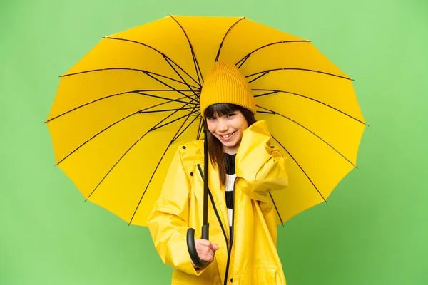 小さな女の子とともにレインプルーフコートと傘上の隔離されたクロマキー背景笑い — ストック写真