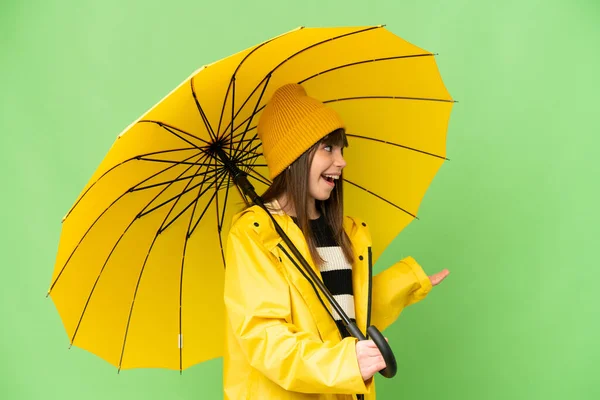 무지개 코트를 우산을 소녀가 표정으로 원색의 배경을 그리며 바라본다 — 스톡 사진