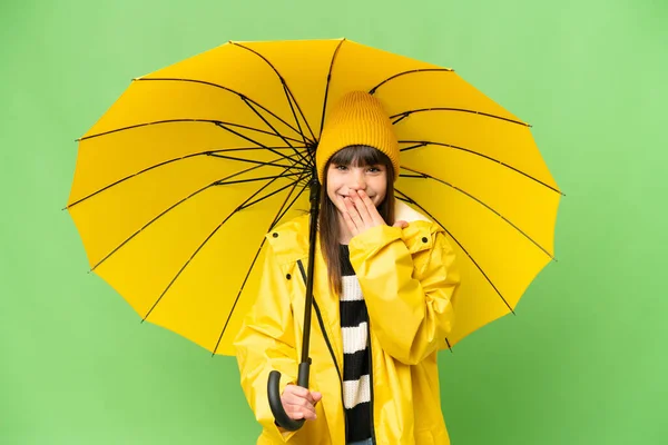 小さな女の子とともにレインプルーフコートと傘上の隔離されたクロマキー背景幸せと笑顔カバー口とともに手 — ストック写真