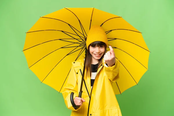 女の子ともにレインプルーフコートと傘上の隔離されたクロマキーバックやりますジェスチャー — ストック写真