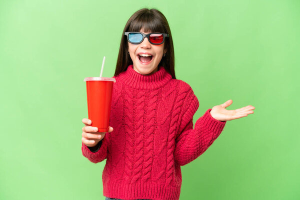 Little girl holding soda over isolated chroma key background with shocked facial expression
