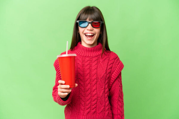 Little girl holding soda over isolated chroma key background with surprise facial expression