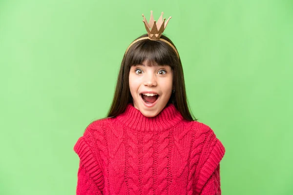 stock image Little princess with crown over isolated chroma key background with surprise and shocked facial expression