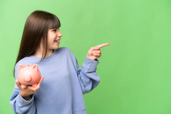 Kleines Mädchen Mit Sparschwein Über Isoliertem Chromaschlüssel Hintergrund Der Zur — Stockfoto