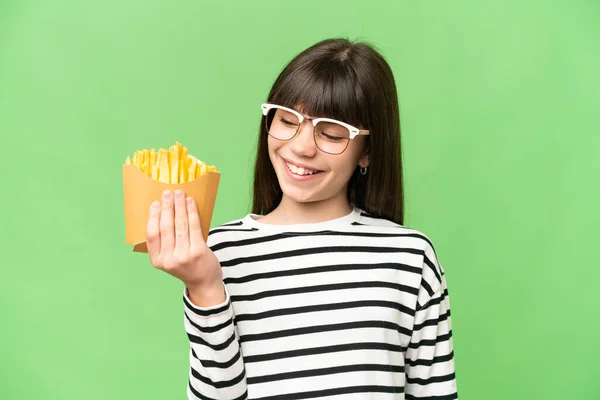 小女孩拿着炸土豆片 带着快乐的表情 紧贴着孤立的彩色背景 — 图库照片