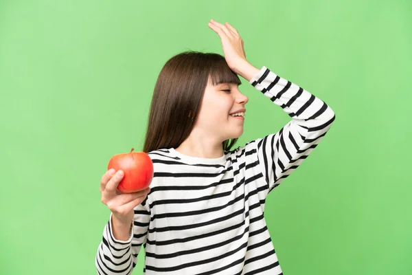 Stock image Little girl with an apple over isolated chroma key background has realized something and intending the solution