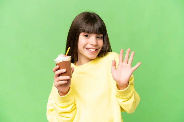 Stock image Little girl with chocolat cream over isolated chroma key background saluting with hand with happy expression