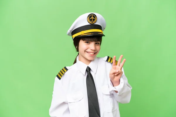 小女孩作为飞机驾驶员在孤立的彩色背景下快乐地数着三根手指 — 图库照片