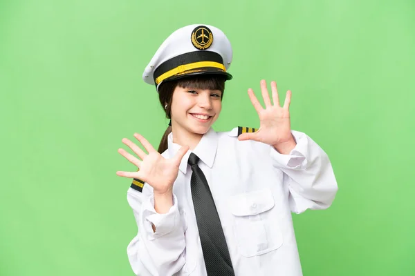 小女孩作为飞机驾驶员 用手指数着10个孤立的着色键背景 — 图库照片
