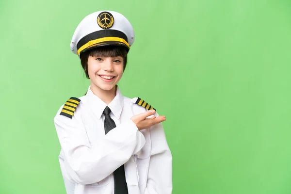 小女孩作为飞机驾驶员 在孤立的彩色背景下展示了一个想法 同时微笑着看着 — 图库照片