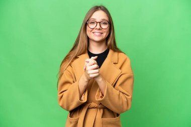 Genç sarışın kadın izole edilmiş krom anahtar arka planda gülüyor.