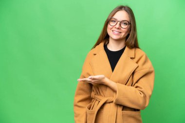 Sarışın bir kadın izole edilmiş krom anahtar arkaplanda bir fikir sunuyor.