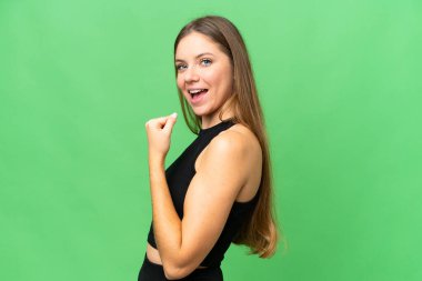 Genç sarışın kadın izole edilmiş krom anahtar arka planda zaferi kutluyor.