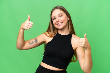 Sarışın, izole edilmiş, anahtar geçmişi olan genç bir kadın baş parmak işareti yapıyor.