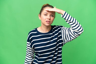 Sarışın, izole edilmiş, anahtar arka planı olan genç bir kadın bir şeye bakmak için çok uzaklara bakıyor.