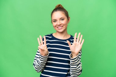 Genç sarışın kadın izole edilmiş krom anahtar arka planda sekiz parmaklı sayıyor.