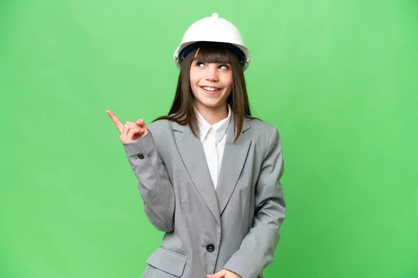 ヘルメットで建築家として遊んでいる女の子と指を持ち上げながら解決策を実現しようと孤立した背景の上に設計図を保持 — ストック写真